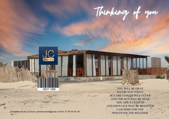 Modern beachfront building at sunset with text "Thinking of you."