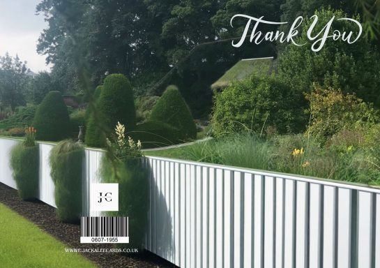A landscaped garden with neatly trimmed hedges and a decorative fence.