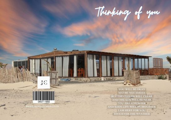 Modern wooden house on a sandy beach at sunset, with clouds and text overlay.