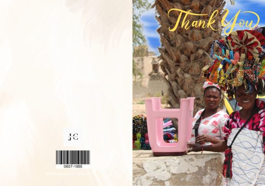 Two women stand beside a large pink letter "U," with vibrant decorations in a sunny outdoor setting.