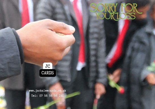 JC 0034 A hand holding a small object, with several people in the background holding roses.