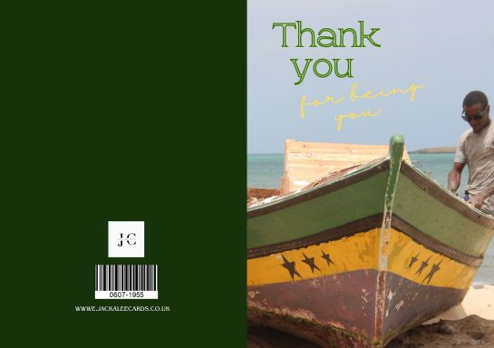A man stands near a brightly coloured boat on the shore, with a "Thank you" message nearby.