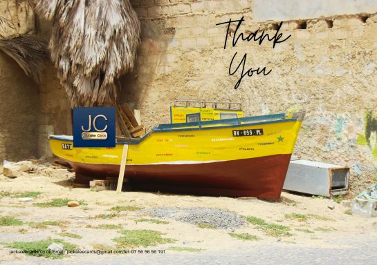 A yellow fishing boat resting on sand with a "Thank You" message above it.
