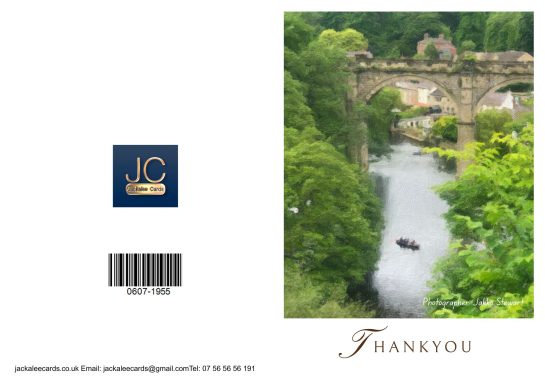 A scenic view of a river surrounded by lush greenery and a stone bridge.