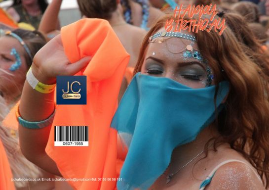 A woman with vibrant red hair wearing a blue face covering and an orange top at a festival.
